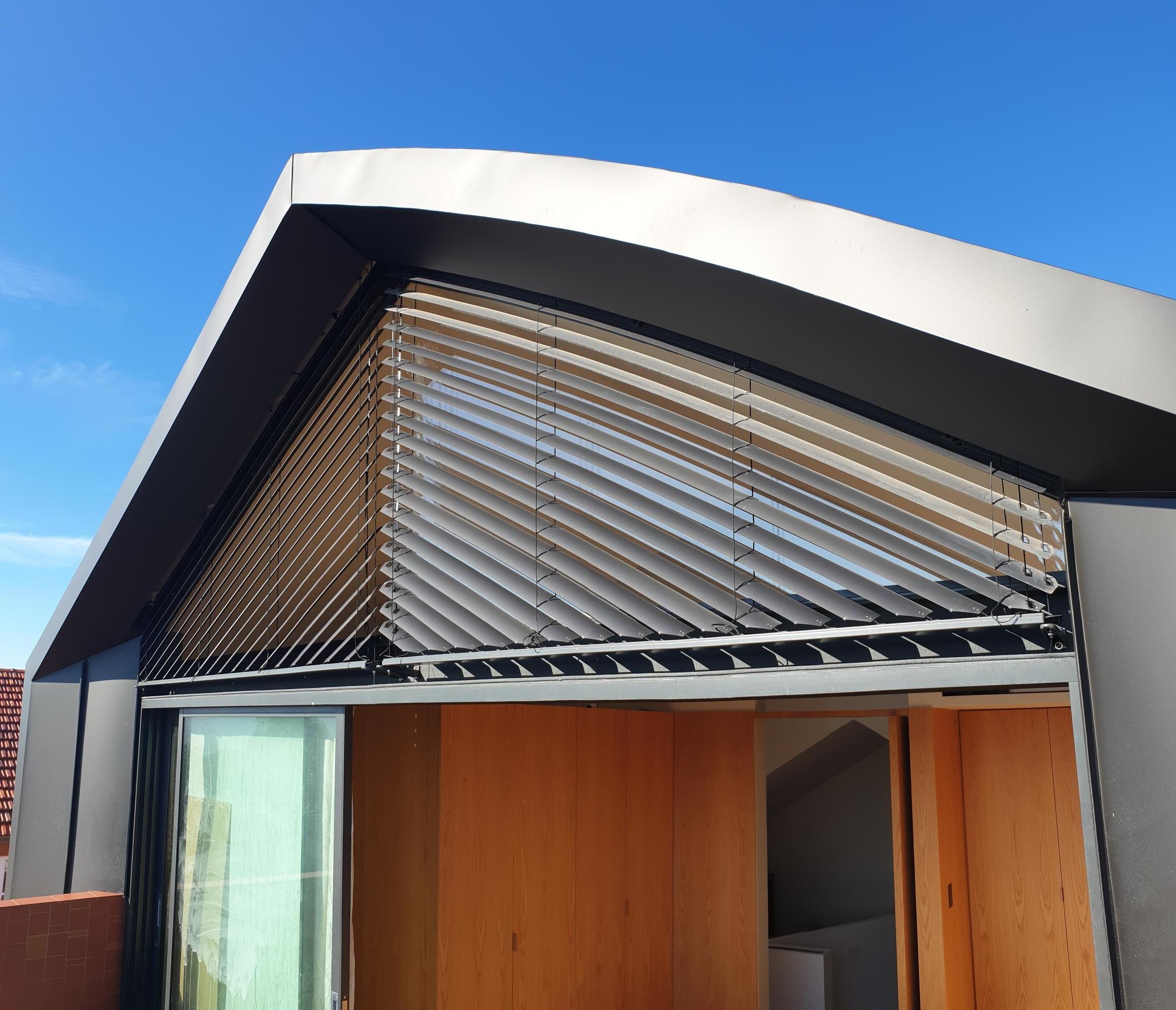 Asymmetrical external venetian blinds on a window