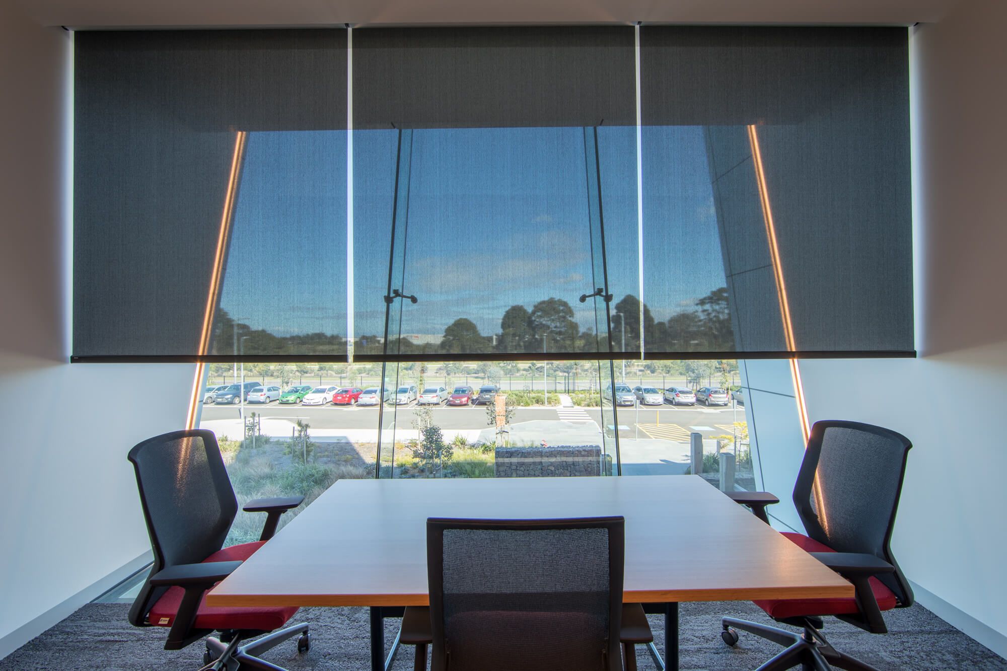 Internal roller blinds blocking glare in an office space