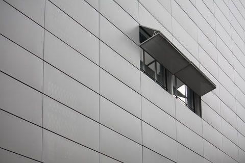 Motorised horizontal bi-fold screens on the facade of the building
