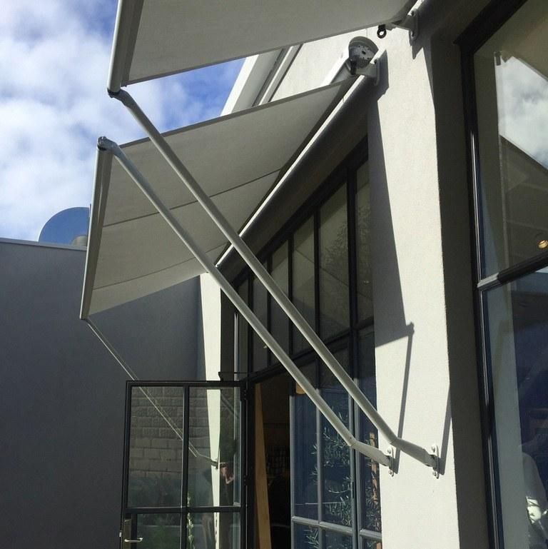 Worm's eye view of drop arm awnings installed on Country Road's windows in Melbourne